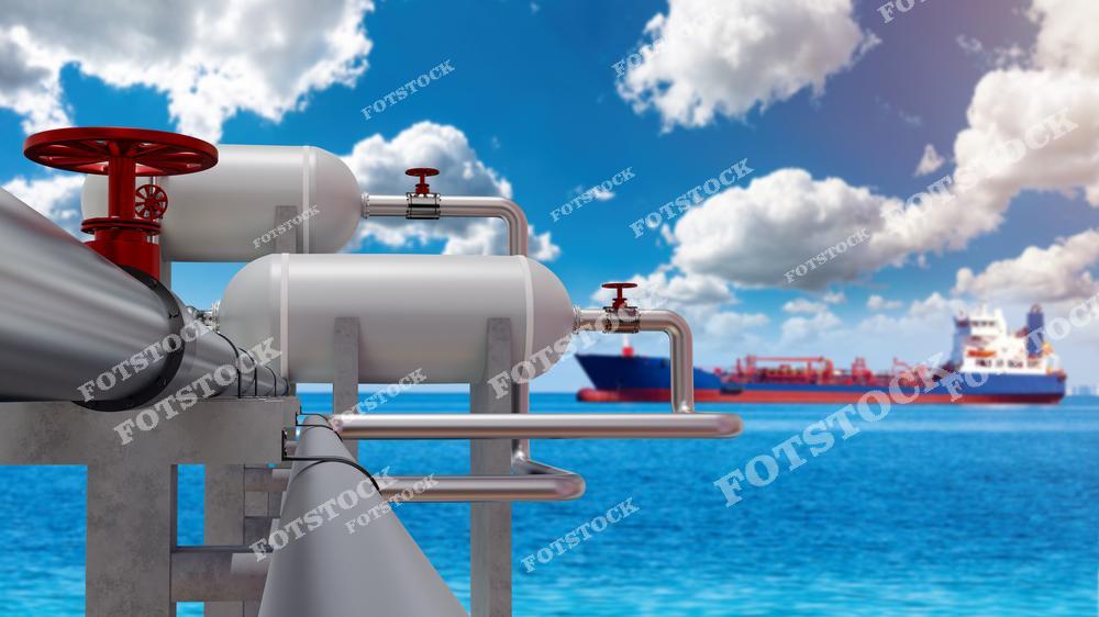 На изображении представлены белые газовые резервуары и трубопроводы с красными вентилями, расположенные на фоне синего моря и кораблей. Танкер вдалеке подчеркивает международную транспортировку газа и нефти. Фотография отражает важность логистической и портовой инфраструктуры в энергетической отрасли.